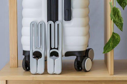 Kangaroo Fold hangers folded compactly beside a suitcase